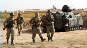 Turkish soldiers walk as they stand guard on the Turkish-Syrian border near the Akcakale border crossing