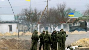 Armed men, believed to be Russian soldiers, stand near the Ukrainian naval base at the Crimean port of Yevpatorya