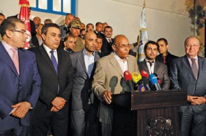 Tunisian President Marzouki flanked by released diplomats Ben Cheikh and Kontassi, speaks to the press at the Aouina military airport in Tunis