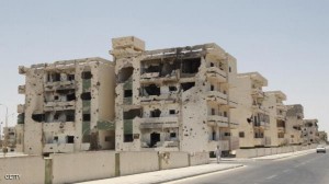 A Libyan man walks past a damaged buildi